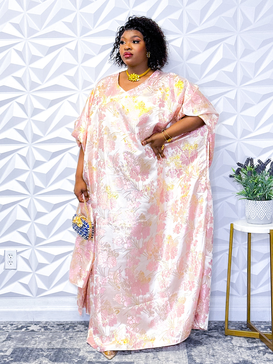 Woman wearing a pink floral jacquard kaftan dress with intricate design, exuding elegance and comfort.