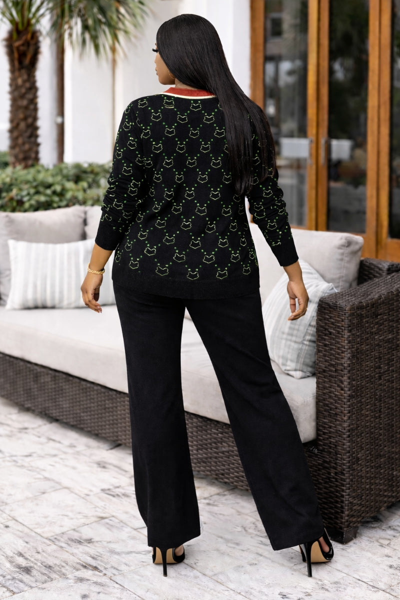 Woman wearing a black outfit with a pattern, standing in an outdoor setting.