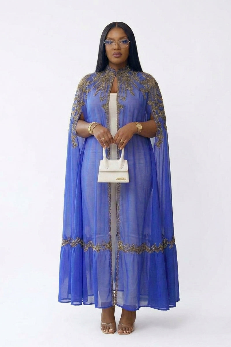 Woman wearing a blue dress with gold embroidery on a white background