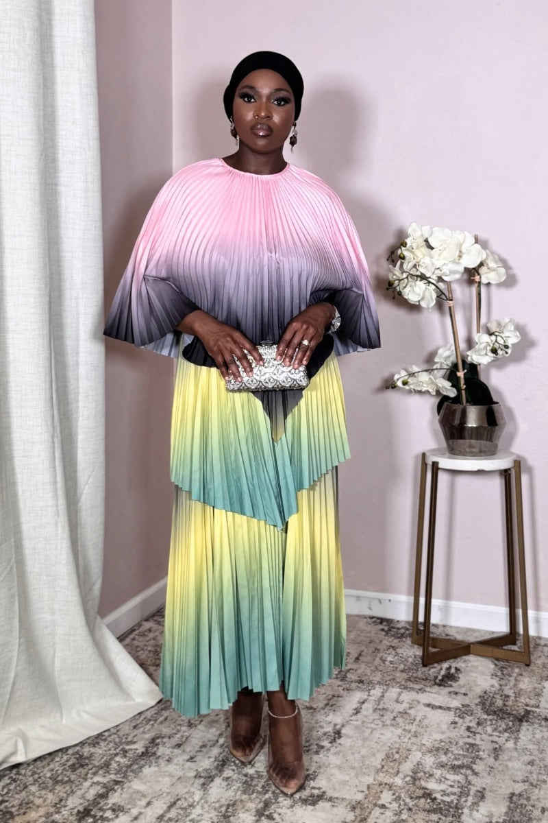Model wearing Aurora Meadow Bloom Pleated Cape Set in pastel pink, lavender, mint, and yellow ombré.