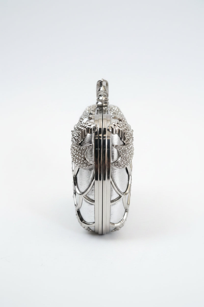 Decorative clutch bag with intricate design on a textured surface