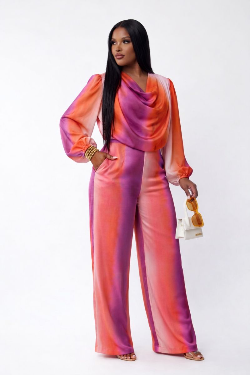 Model wearing Sunset Glow Satin Cowl-Neck Set in watercolor sunset print with coral, pink, orange, and lavender.